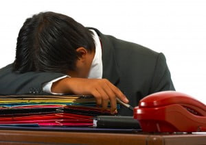 Overloaded Worker Having A Nap On His Desk